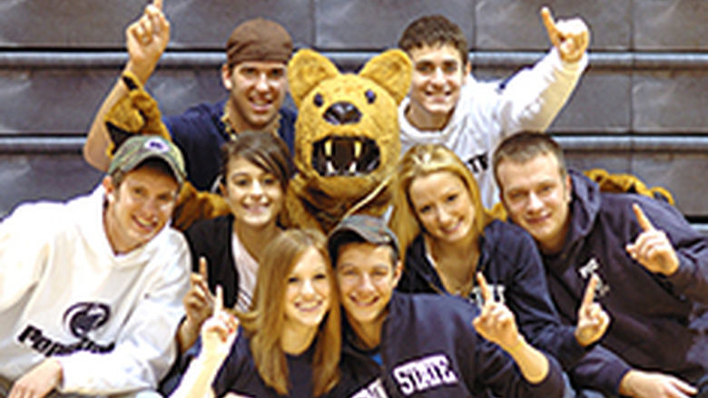 Student Lion Ambassadors gathered around the Nittany Lion mascot, signaling "We're number 1!" by holding up their index fingers.
