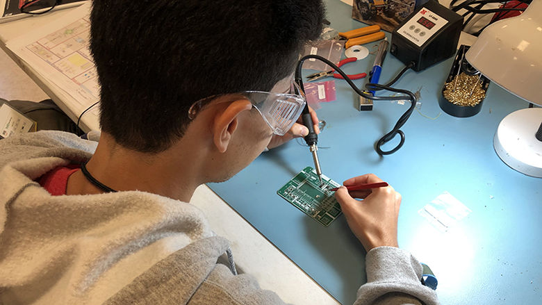 Pablo soldering a circuit board for the payload