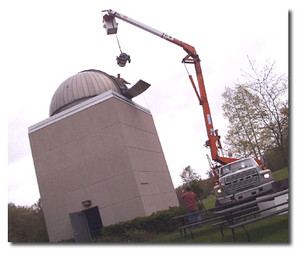 new telescope being hoisted into observatory by crane