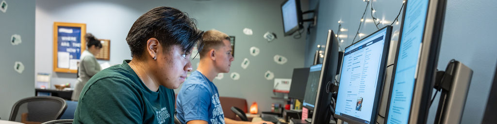 Two students working in front of computers in the SSS office