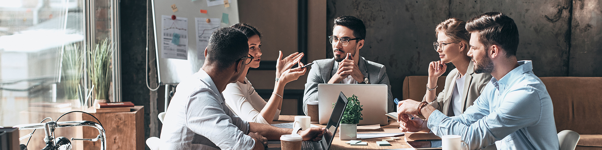 Group of young people discussing business while having meeting in the office