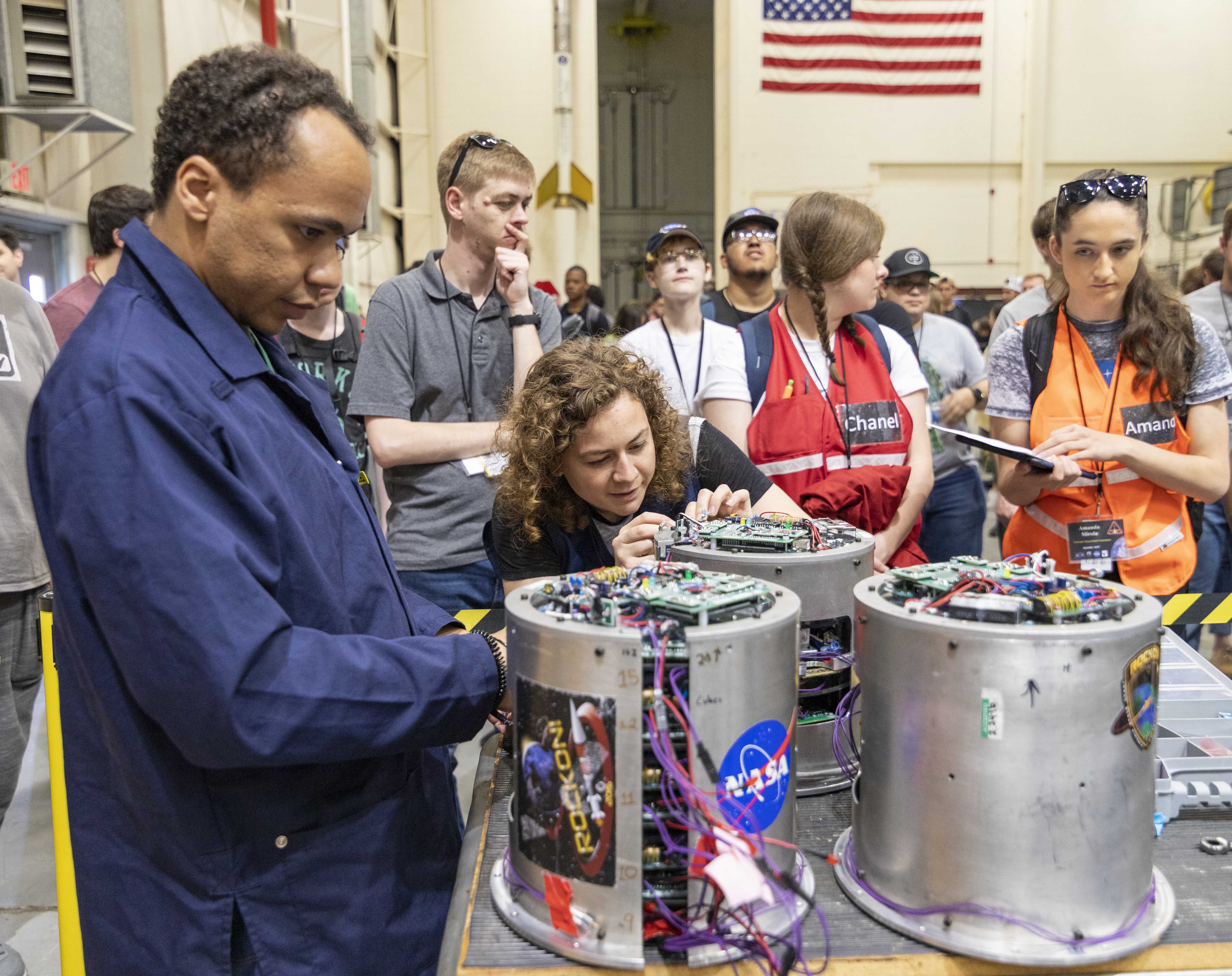 Students and NASA staff examining payloads before installing them in the rocket