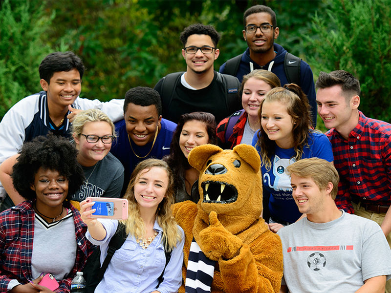 students taking a group selfie with the Nittany Lion mascot