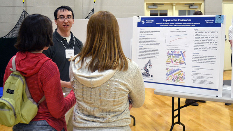 student presenting his poster at the Celebration of Scholarship event on campus