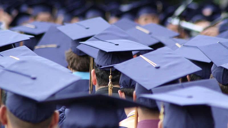 a large crowd of graduating students; only the tops of their mortarboards are visible