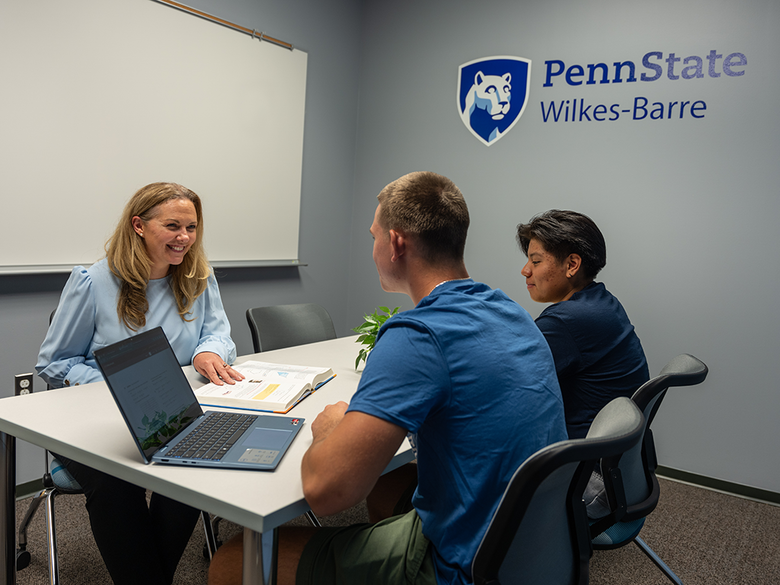 Two students in a tutoring session with a Student Support Services staff member