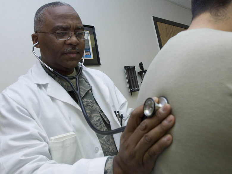 Black doctor examining white patient