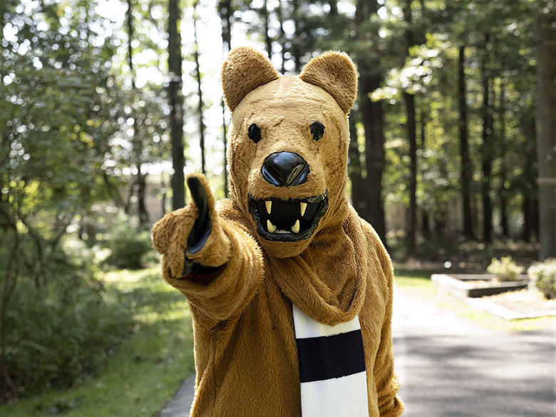 The Nittany Lion mascot gesturing in invitation