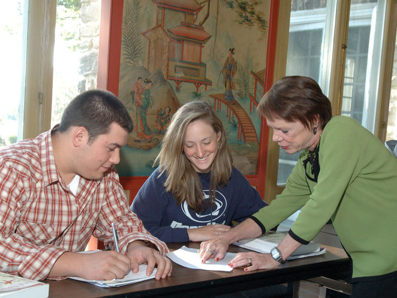 A faculty member discussing a paper with two students