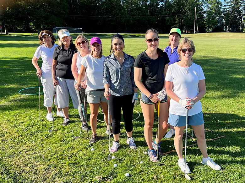 A group of women golfers posing with their clubs