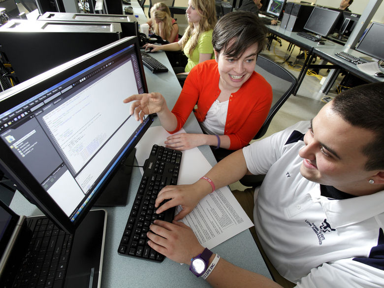 Student and faculty member working side-by-side in front of a computer