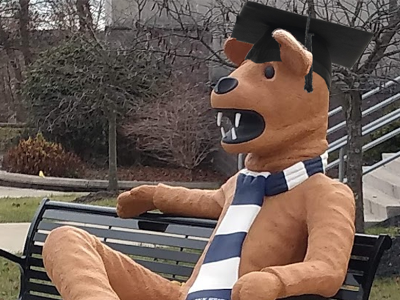 Nittany Lion statue wearing a mortarboard and sitting on bench in front of the Struthers Career Services Center
