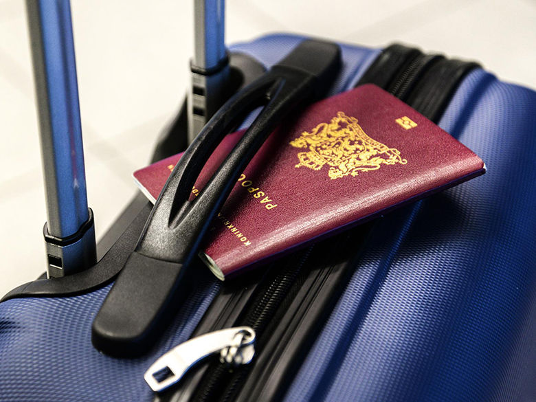 a suitcase with a passport tucked under the handle