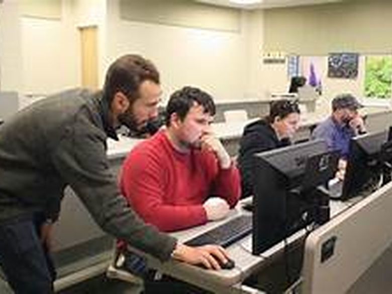 Faculty member working with a student in a computer lab