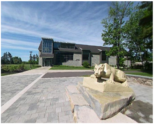 the Nittany Lion statue in the foreground; the Academic Commons building in the distance