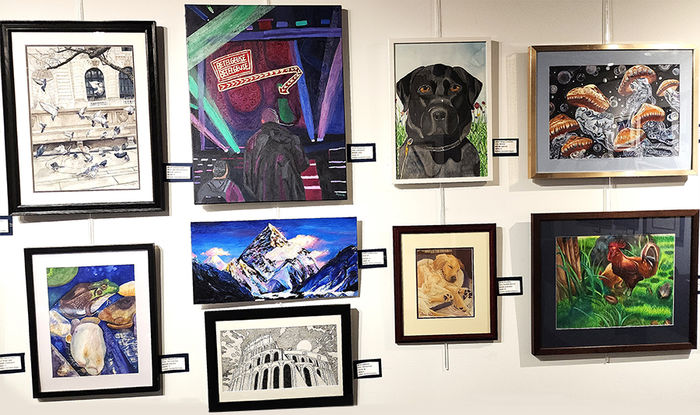 Nine pieces of artwork from the 5th Annual High School Art Exhibit hanging on the Friedman Art Gallery wall