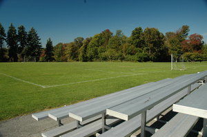 The athletic fields on a sunny day, with aluminum bleachers in the foreground