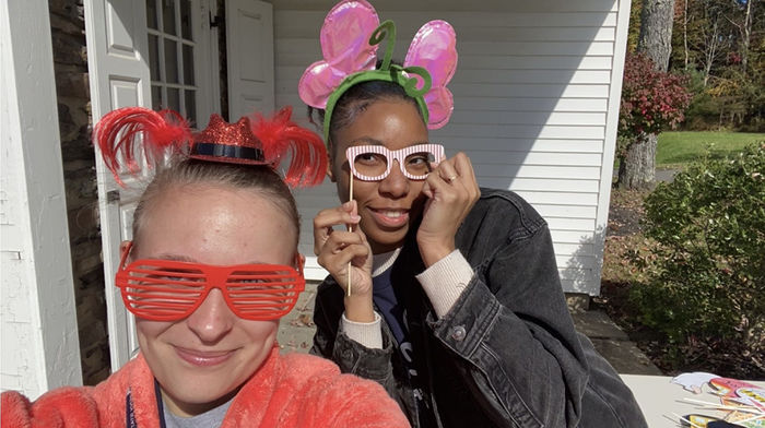 Two students in silly glasses and headbands taking a photo of themselves.