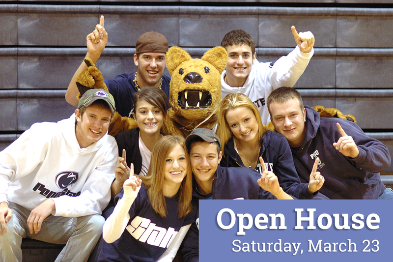 Students gathered around the Nittany Lion mascot on bleachers in the gym. They are all holding up their index fingers in the "We're number one!" sign.