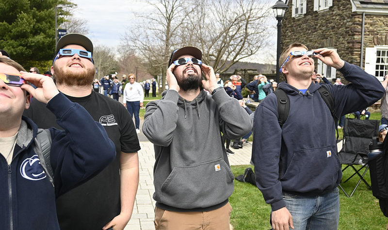 People looking at the sky wearing eclipse glasses.