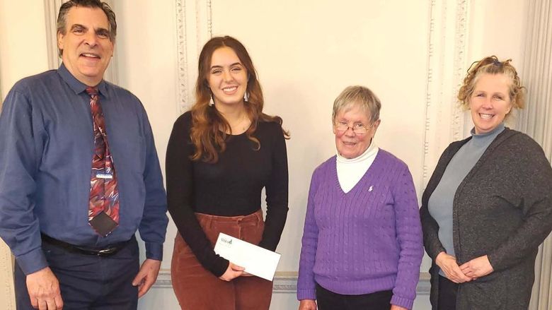 Four people standing together for a check presentation
