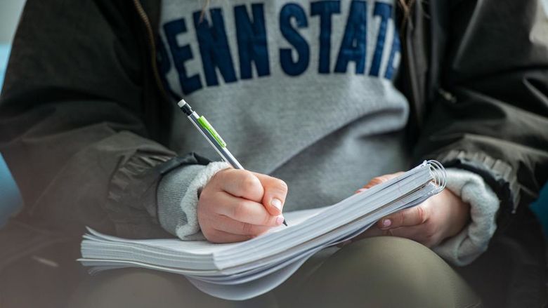 A close-up image of a student writing in a notebook.