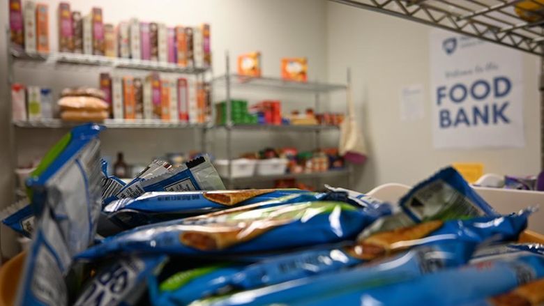 A close-up of granola bars with other food on shelves in the background