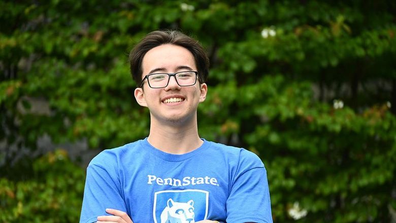 A man in glasses wearing a blue T-shirt with the Penn State logo and the words "Penn State Wilkes-Barre" standing with his arms crossed.