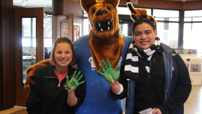 Students with their hands covered in green paint 