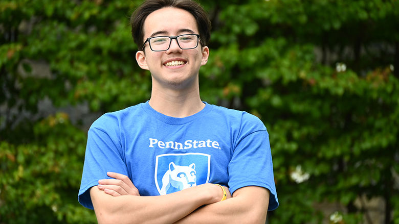 A man in glasses wearing a blue T-shirt with the Penn State logo and the words "Penn State Wilkes-Barre" standing with his arms crossed.