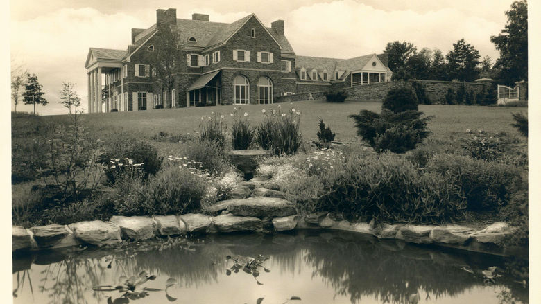 A black-and-white image of a country mansion