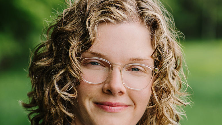 A headshot of a woman in glasses outdoors