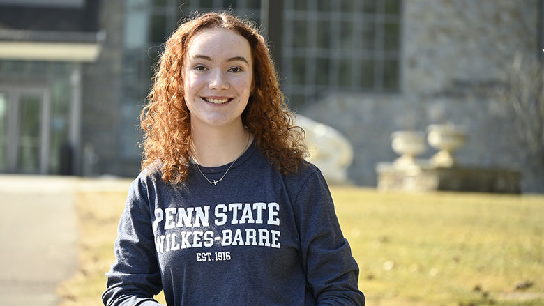 An image of a woman standing outside wearing a shirt that says "Penn State Wilkes-Barre Established 1916"