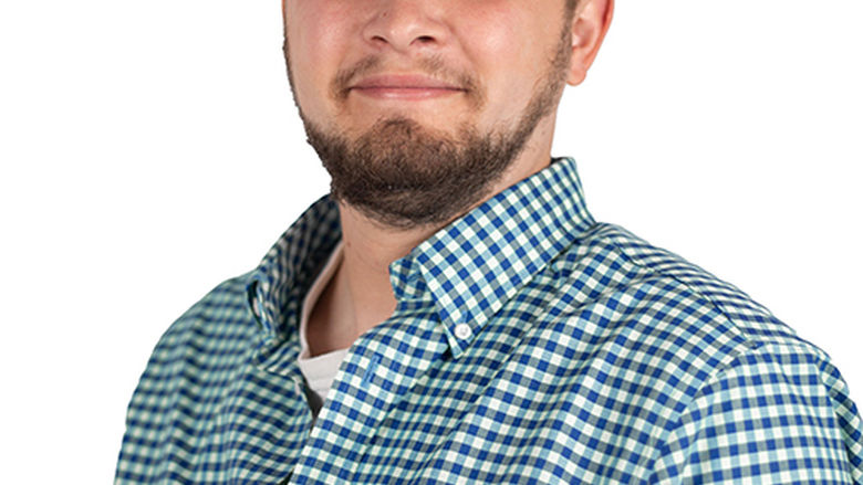 A man in a button-down shirt against a white background.