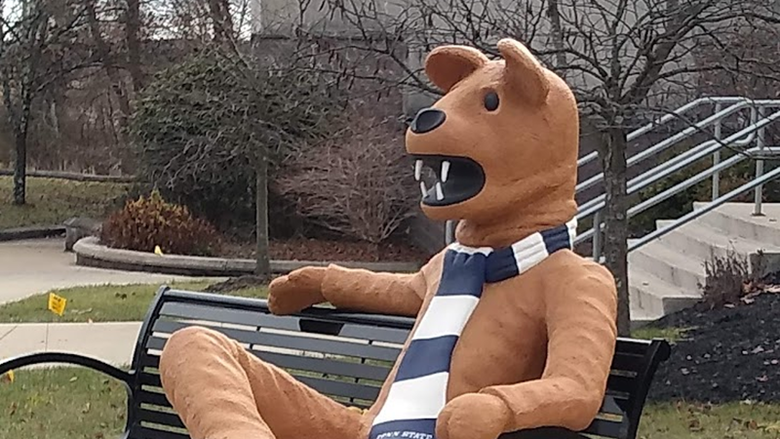 Nittany Lion statue sitting on bench in front of the Struthers Career Services Center