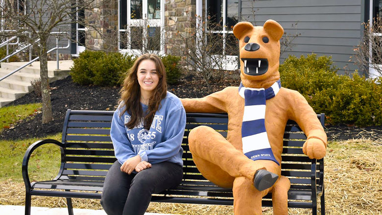 Cloe Mazzatosta sitting on Penn State Wilkes-Barre's new Nittany Lion bench