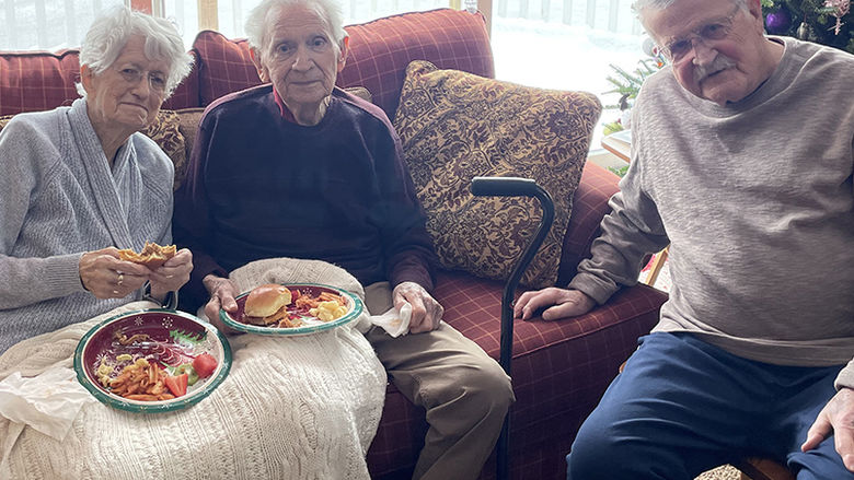 From left: a woman and a man sitting on a couch and a man sitting on a chair.