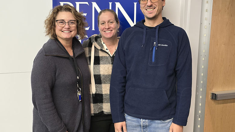 Three people standing and smiling at the camera.