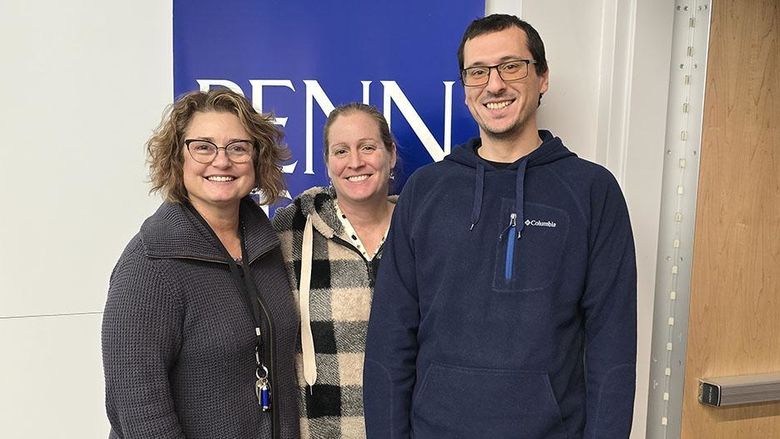 Three people standing and smiling at the camera.