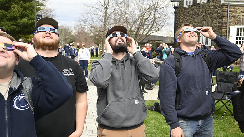People wearing special glasses while looking at the sky.