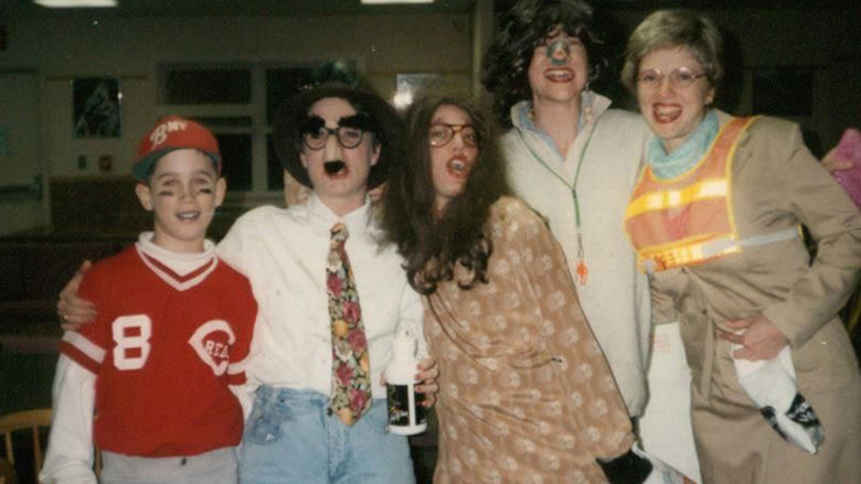 Five people standing in a row dressed in Halloween costumes.