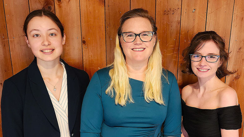 Three women standing next to each other.