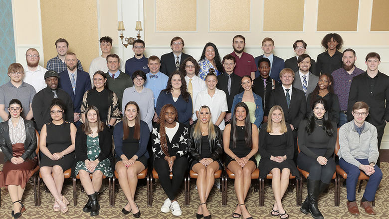 A large group of students posing indoors in several rows.