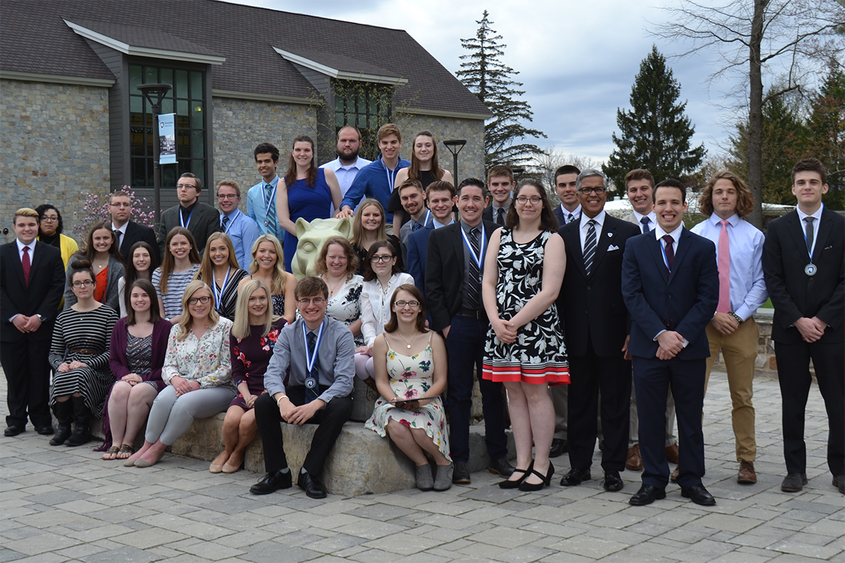 Academic award winners as a group posing in front of the lion shrine on campus