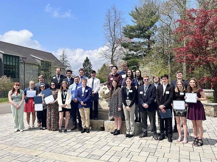 Large group of students in front of Nittany Lion statue