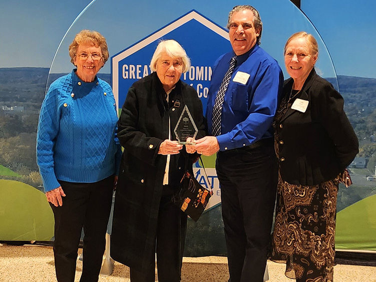 Four people standing and holding an award