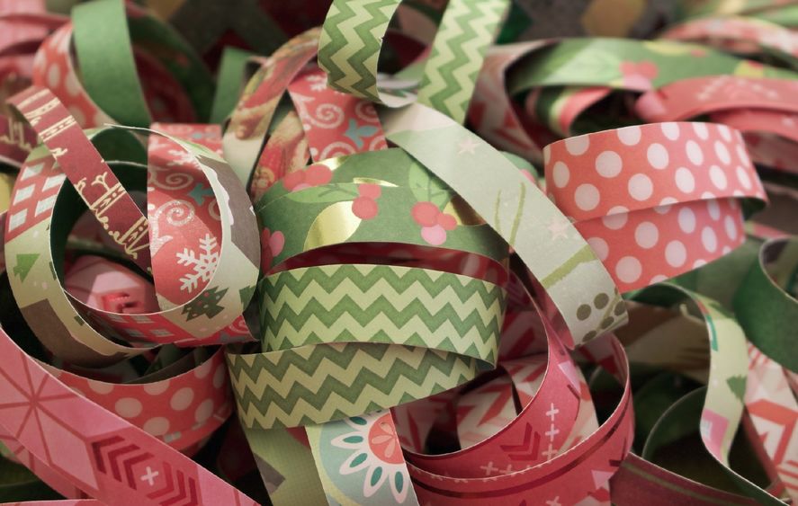 A close-up image of rolls of pink and green ribbon