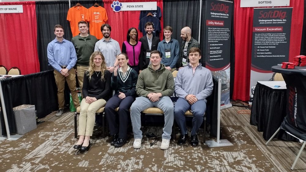 A group of students and faculty at a conference booth