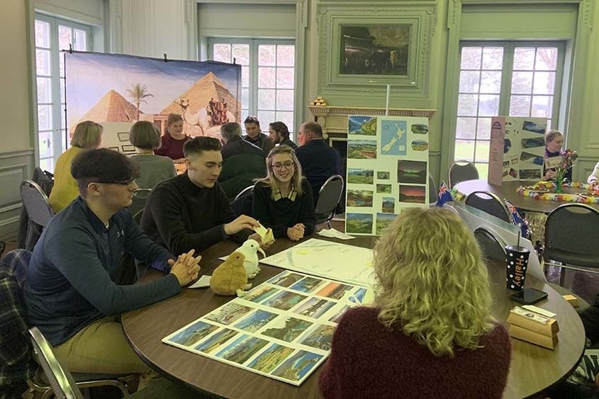 Students seated at a table for presentations.