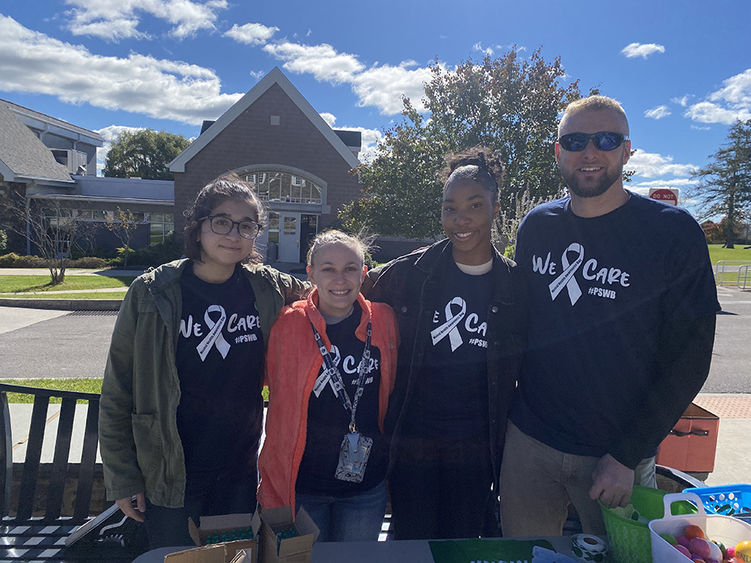 A group of student volunteers in matching T-shirts that say "We Care"